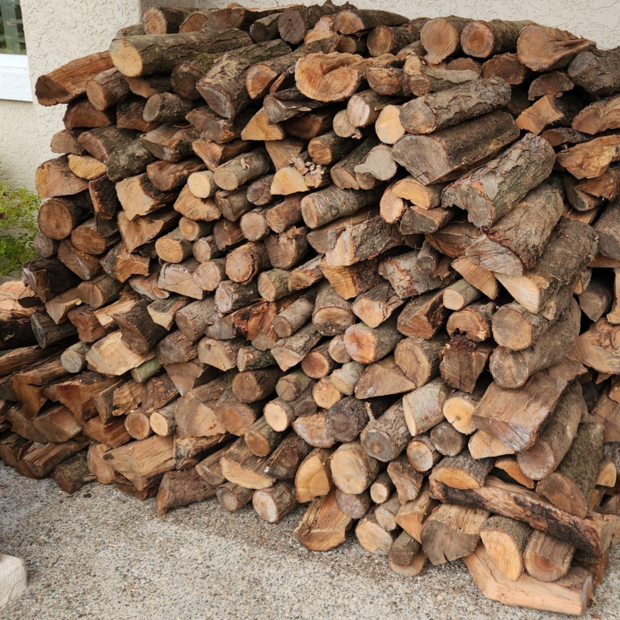 1 /2 cord stack of almond firewood against house in Granite Bay CA.