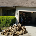 a pile of firewood in driveway outside a house 